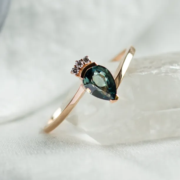 Angled view of the LEAH gold ring with teal sapphire and diamonds