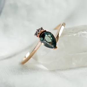 Angled view of the LEAH gold ring with teal sapphire and diamonds