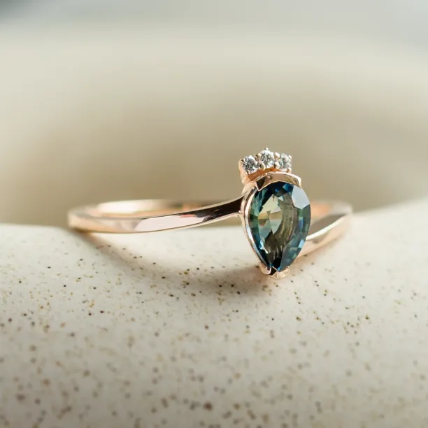 Close-up of the LEAH ring with a pear-shaped teal sapphire and diamonds