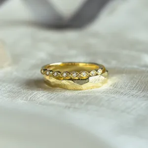 Close-up of DARLING diamond wedding bands with hammered and eternity details