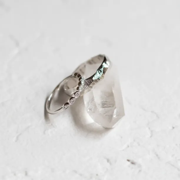 Angled view of DARLING diamond wedding bands with textured detailing