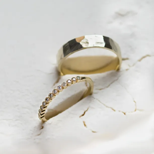 Close-up of the diamond eternity wedding ring with the hammered band behind