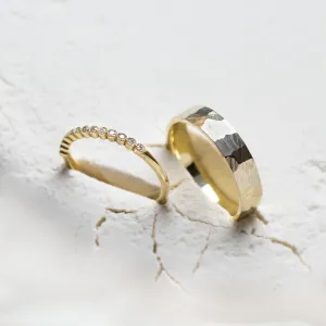 Angled view of the diamond eternity ring and hammered wedding band