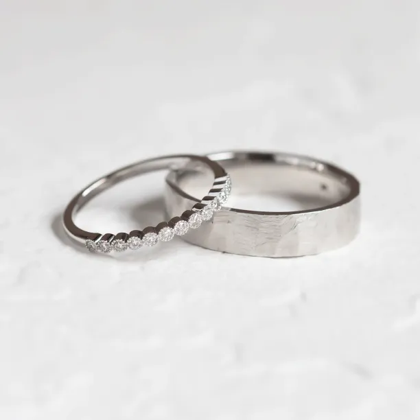 Wedding ring pair with a diamond eternity ring beside a hammered band