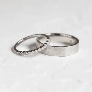 Wedding ring pair with a diamond eternity ring beside a hammered band