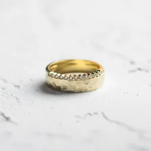 Close-up of a diamond wedding ring with a hammered surface