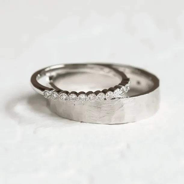Close-up of the PAIR wedding rings with diamonds and hammered surface