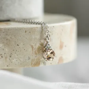 Angled close-up of FEMINA necklace pendant with morganite and side diamonds