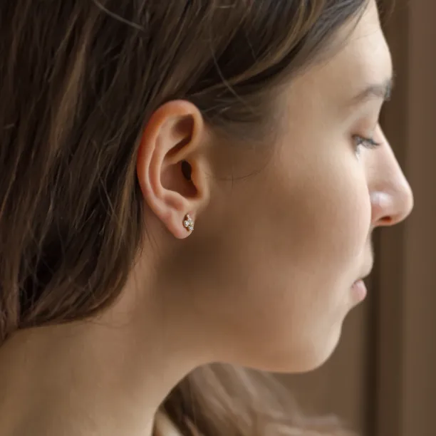 Gold diamond cluster earring worn on the ear