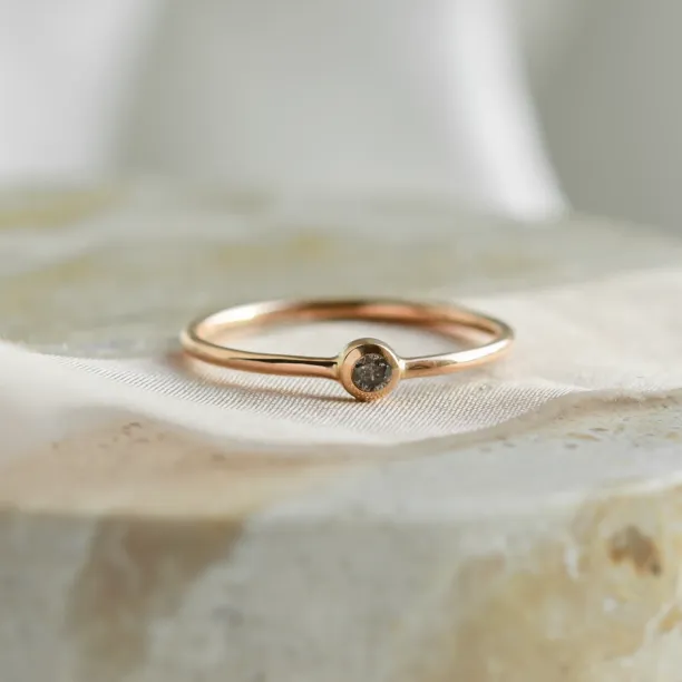 Detail minimalistického zlatého zásnubního prstenu FLAIR se salt and pepper diamantem v bezel osazení