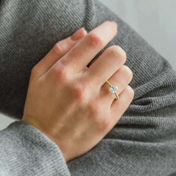 CLEA beaded engagement ring with radiant moissanite worn on the hand