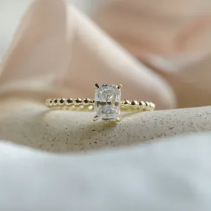 Close-up of the CLEA beaded engagement ring and radiant moissanite