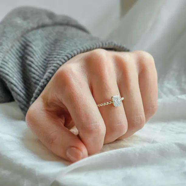 CLEA beaded engagement ring with radiant moissanite worn on a hand