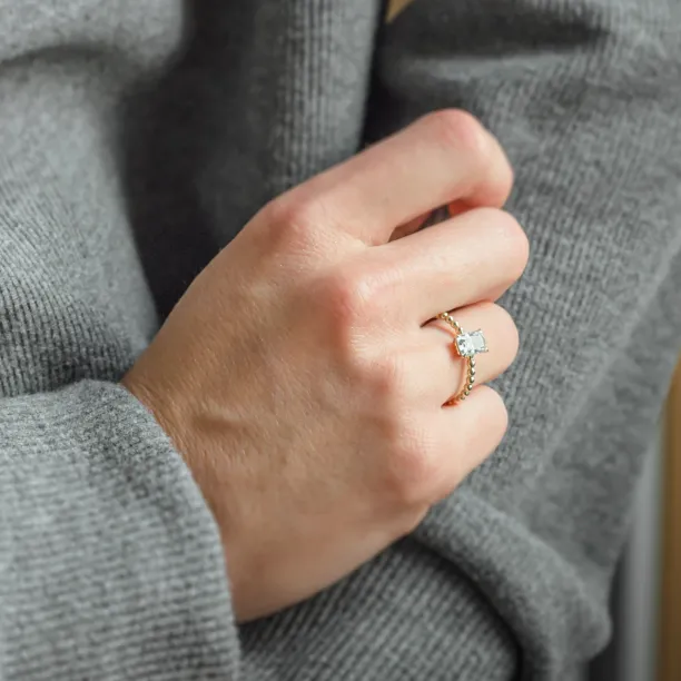Close-up of the CLEA radiant moissanite ring worn on the hand