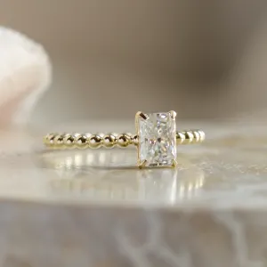 Close-up of CLEA beaded-ball engagement ring with radiant moissanite