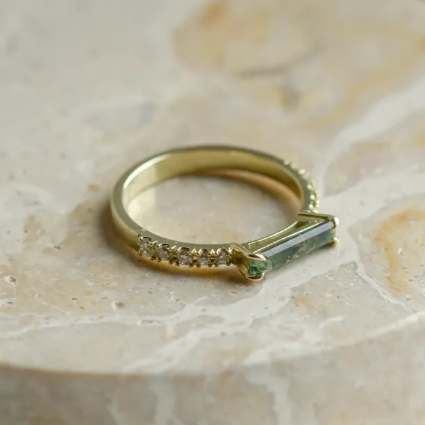 Angled close-up of the MILA engagement ring with baguette moss agate and diamonds