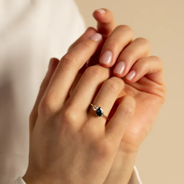 COUPLE engagement ring with blue pear sapphire and round diamond worn on the hand