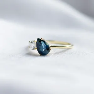 Angled view of the COUPLE Toi et Moi ring with blue pear sapphire and diamond