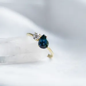 Close-up of the COUPLE ring showing its blue pear sapphire and round diamond