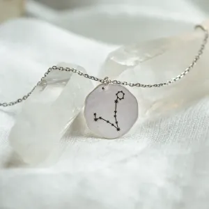 Angled view of the gold STELLARIS necklace and engraved zodiac constellation pendant