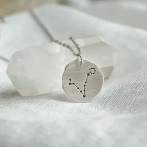 Close-up of the gold STELLARIS necklace pendant with engraved zodiac constellation