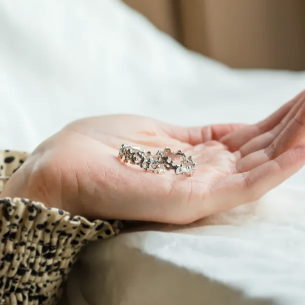 NALANI wedding rings with organic elements resting in an open hand