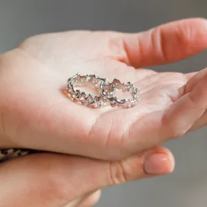 NALANI wedding rings with organic elements held in an open palm