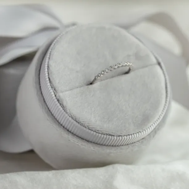 Close-up of the CHRISTINE gold ring with diamonds on a jewelry cushion