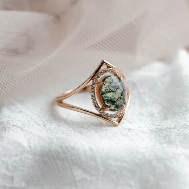 Angled view of the gold PINIA ring with moss agate and diamond surround