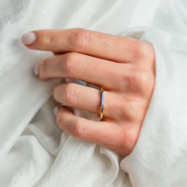 Gold CYNTHIA ring with laboratory sapphire worn on the hand