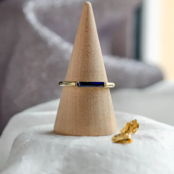 Angled view of the gold CYNTHIA ring with baguette laboratory sapphire