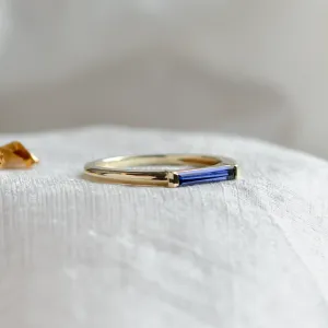 Close-up of the gold CYNTHIA ring and its baguette laboratory sapphire
