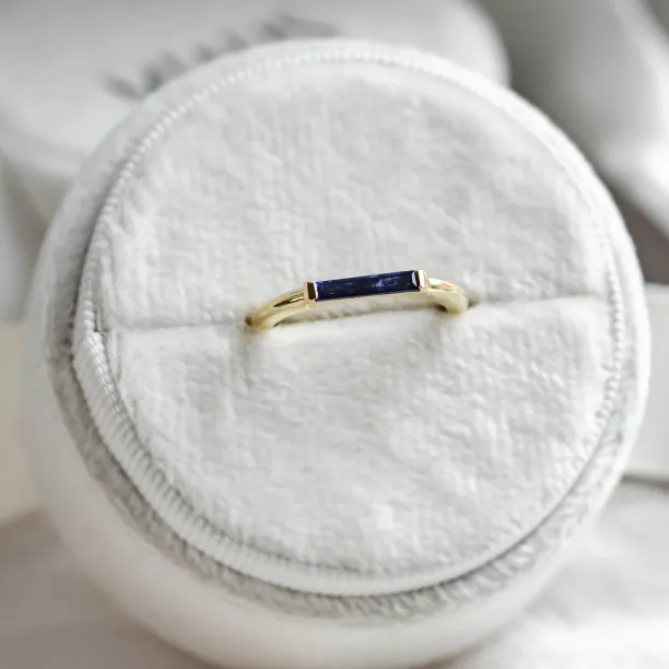 Close-up of the gold CYNTHIA ring with its blue baguette sapphire