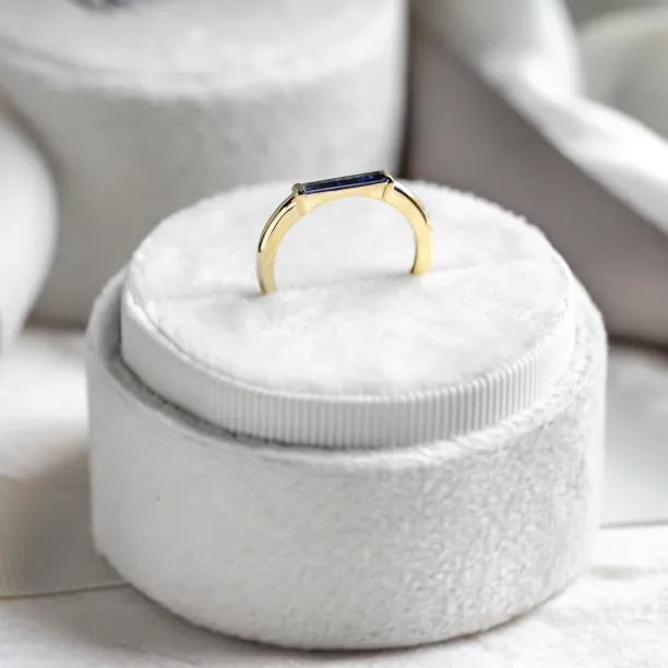 Angled detail of the gold CYNTHIA ring and baguette laboratory sapphire