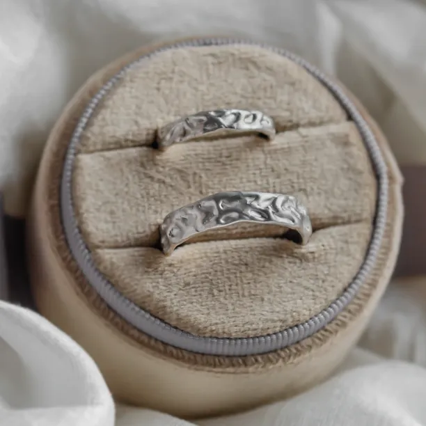 Close-up of ANJA wedding rings showing their organic textured surfaces