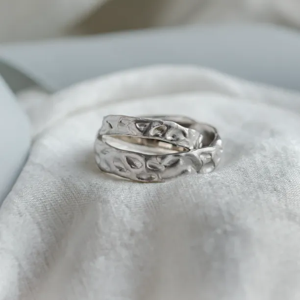 Close-up of overlapping ANJA wedding rings and their textured surfaces