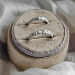Close-up of the textured BECCA gold wedding rings