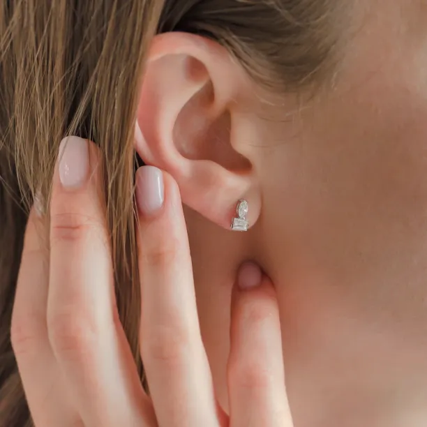 Close-up of a HOLLY earring with marquise and baguette moissanites worn on the ear
