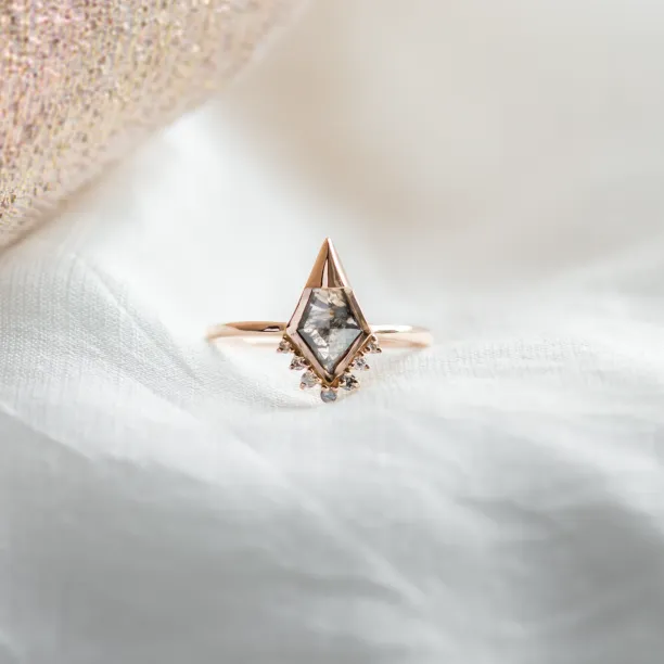 Close-up of ADIRA engagement ring with salt and pepper diamond and surrounding side diamonds