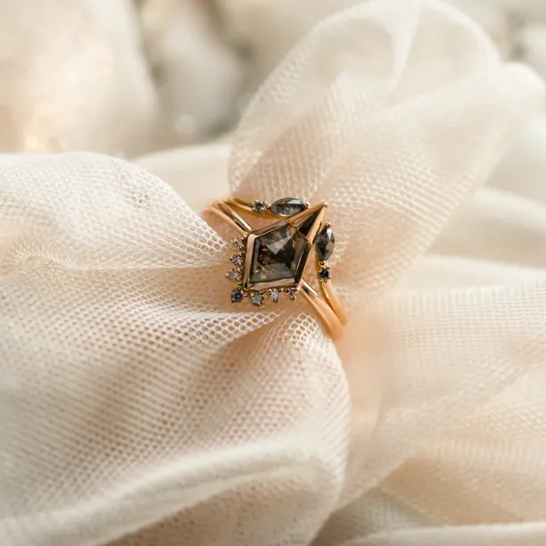 Angled close-up of ADIRA engagement ring with central salt and pepper diamond and side diamonds