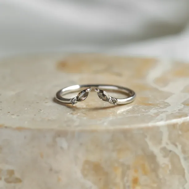 Angled view of gold open ring with salt and pepper diamonds