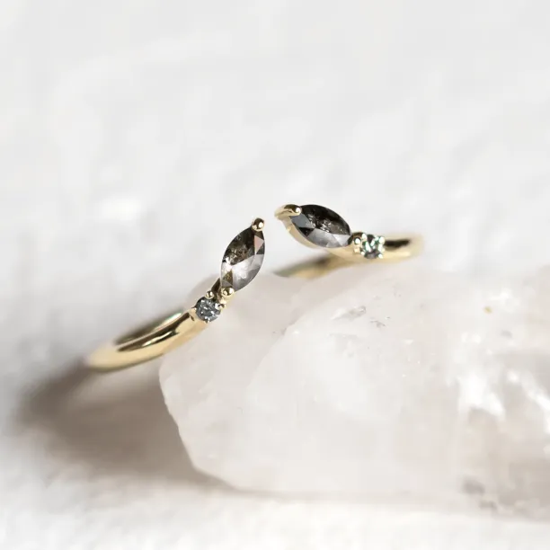 Close-up of gold open ring with salt and pepper diamonds