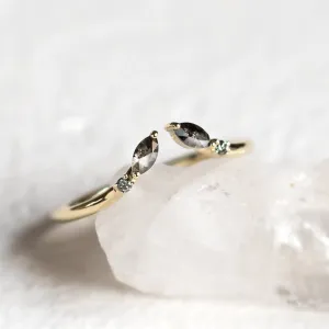 Close-up of gold open ring with salt and pepper diamonds