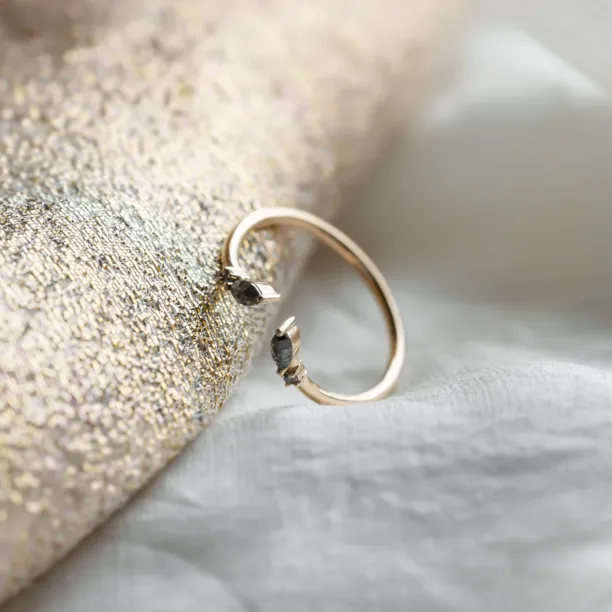 Side view of open gold ring with salt and pepper diamonds
