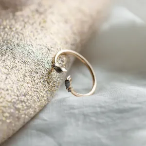 Side view of open gold ring with salt and pepper diamonds