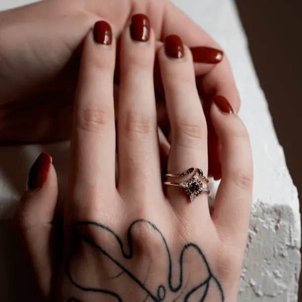 Gold open ring with salt and pepper diamonds worn alongside another ring