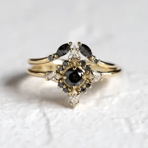 Close-up of open gold ring with salt and pepper diamonds paired with another ring