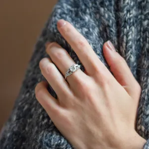 GINNY ring with moissanites worn on a hand, close-up view