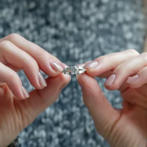 GINNY atypical ring with moissanites held between fingers