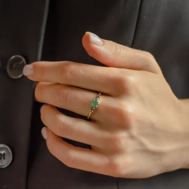 KIM gold ring with emerald and salt and pepper diamonds worn on the hand